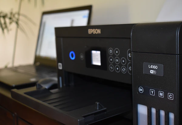 Impresora EPSON L4160 junto a una laptop.
