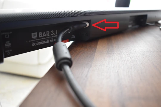 Cable HDMI conectado al puerto HDMI ARC de una barra de sonido JBL