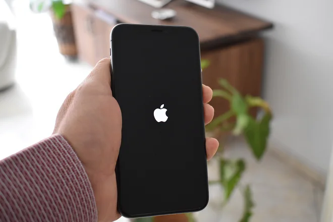 la imagen muestra un iPhone con la pantalla negra y su logo al centro.